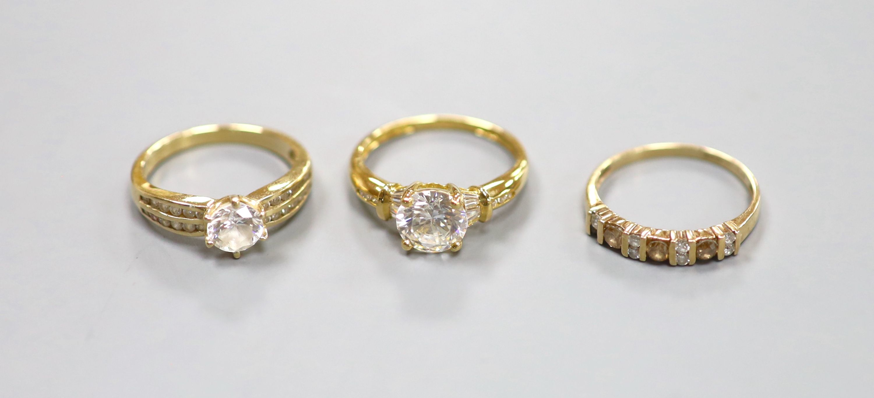 An 18ct gold paste-set solitaire ring, a similar 14ct gold ring and a 9ct gold, diamond and gem-set ring